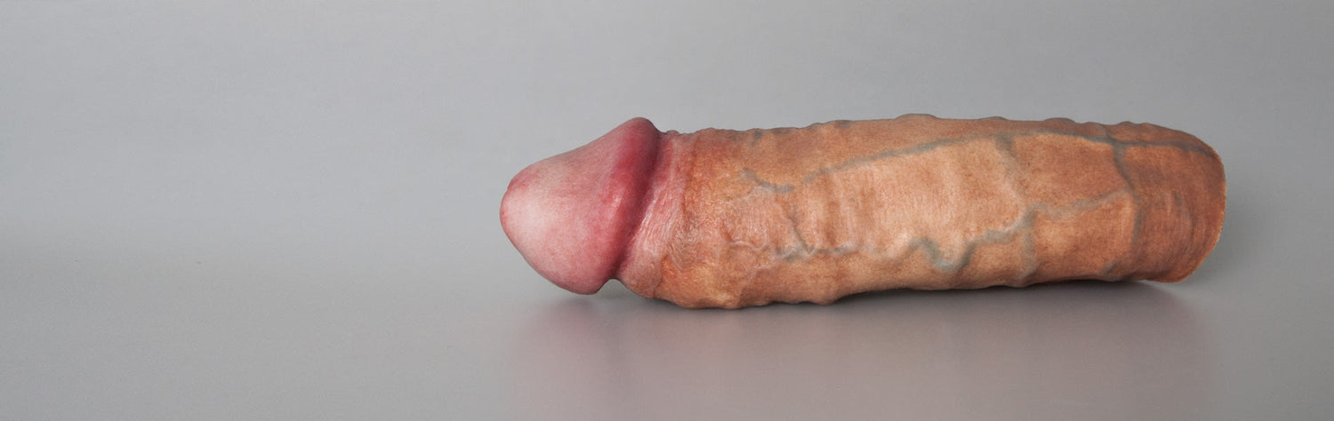 Ultra-realistic Emisil FTM prosthetic with harness, detailed skin tone design, product on white